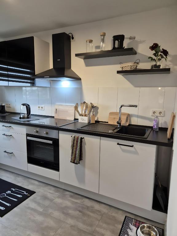 a kitchen with white cabinets and a sink and a stove at Neu 4 Zi Kü Bad Coll-mar in Neunkirchen