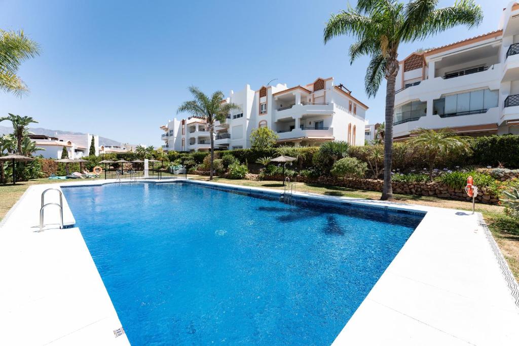 a swimming pool in front of some apartment buildings at Apartamento Los Iris in Mijas