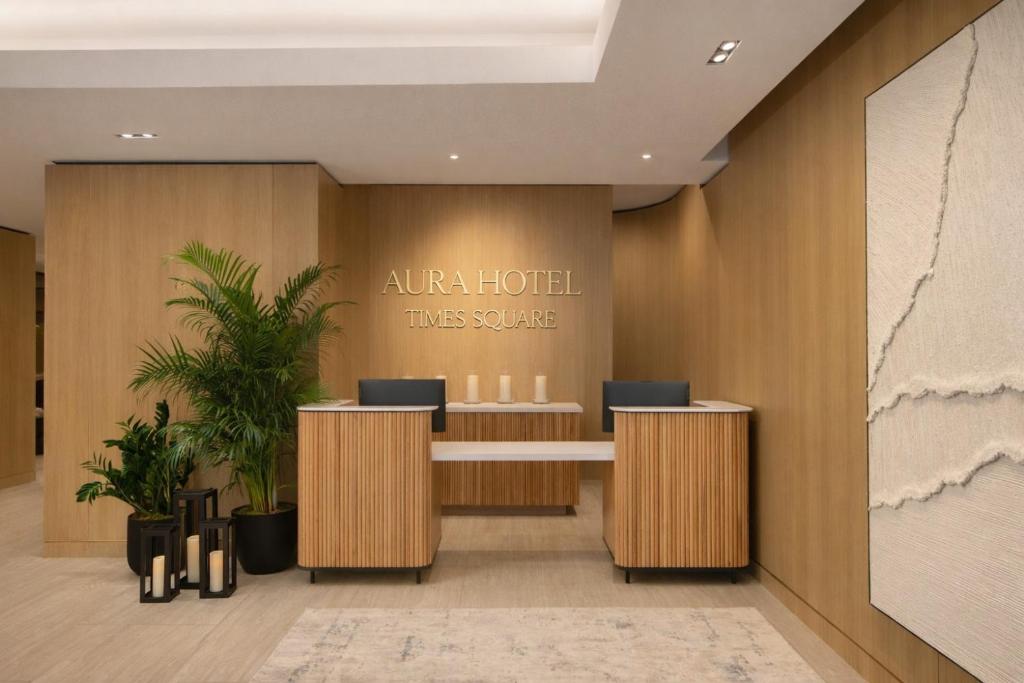 an office lobby with a reception desk and a sign at Aura Hotel Times Square in New York