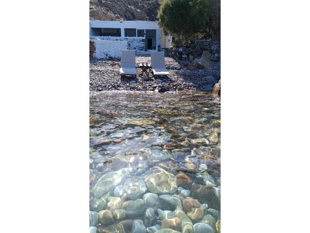 two chairs are sitting in a river of rocks at Seagull Syros Seaside in Ermoupoli