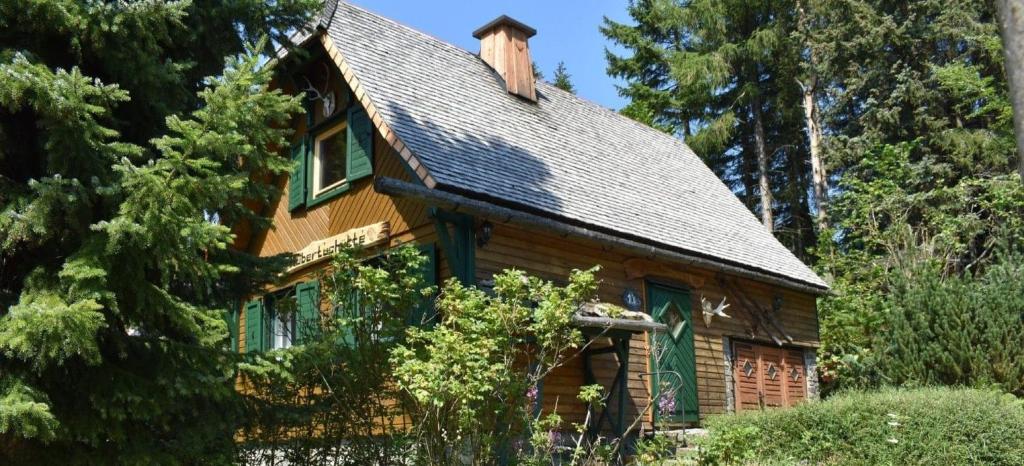 a wooden house with a gambrel roof at Hubertushütte in Kurort Oberwiesenthal