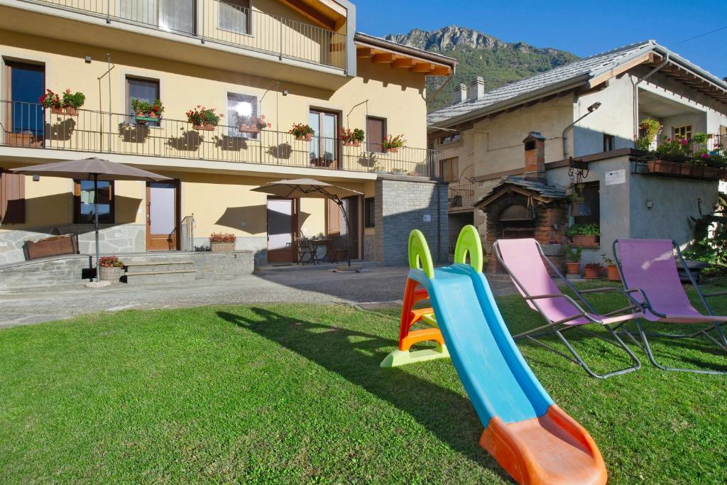 a playground with a slide and chairs in a yard at Agriturismo La Grange in Pont-Saint-Martin