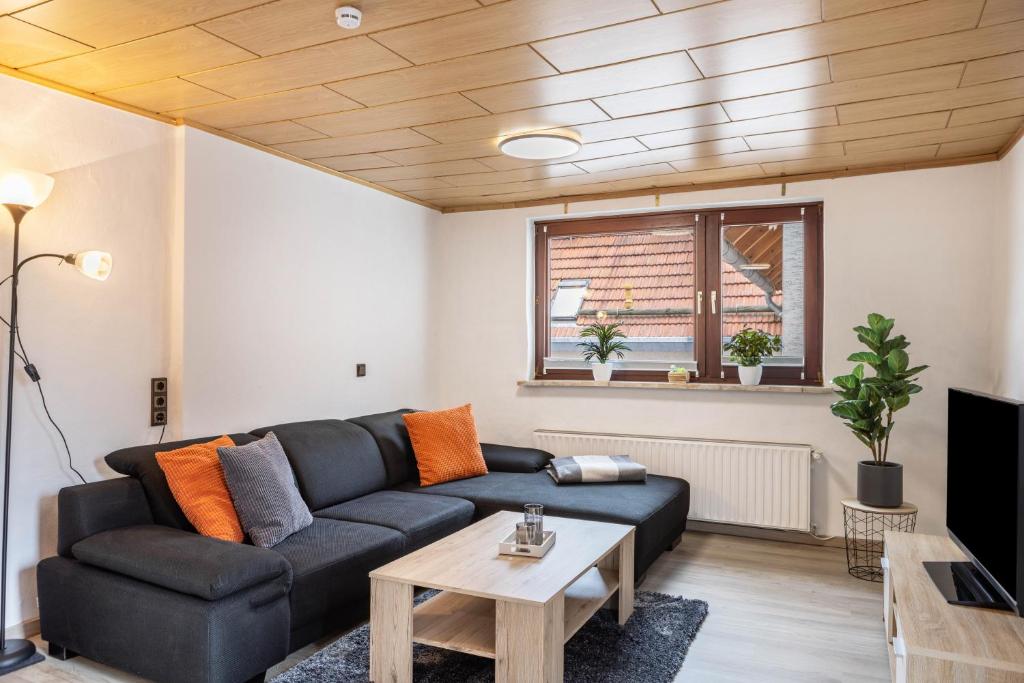 a living room with a black couch and a table at Ferienwohnung Hennen in Witzenhausen