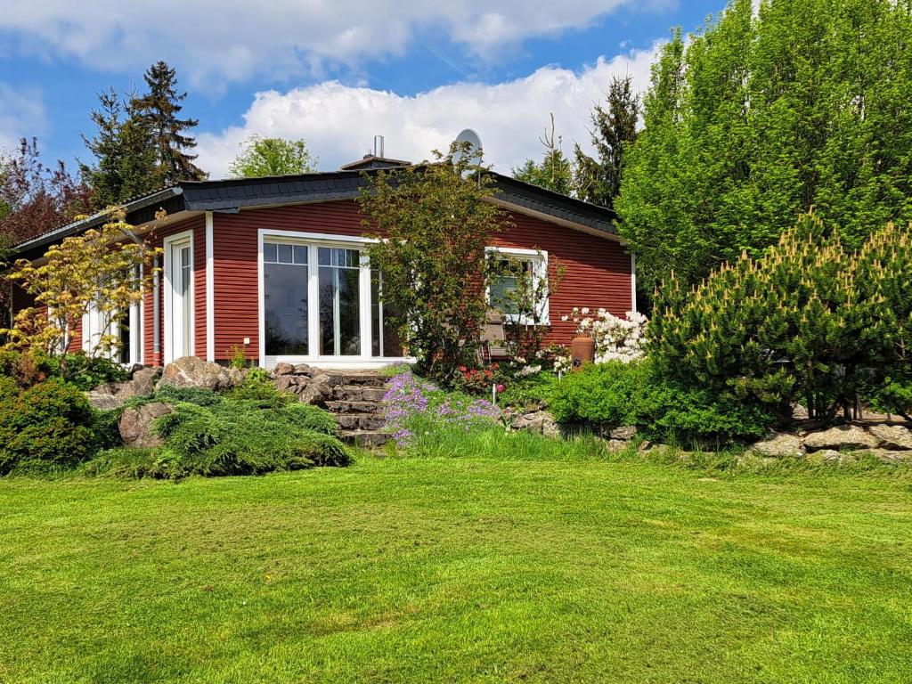 a red house with a yard in front of it at Ferienhaus Chalet Bergblick in Stryck