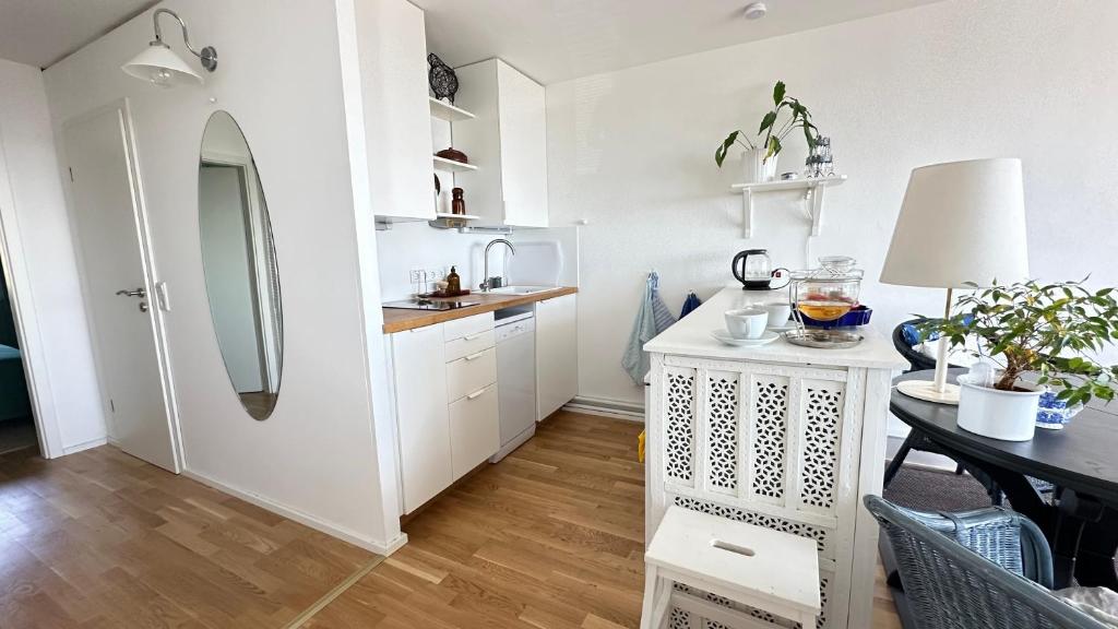 a kitchen with white cabinets and a table with a lamp at Bayerwaldresort in Sankt Englmar