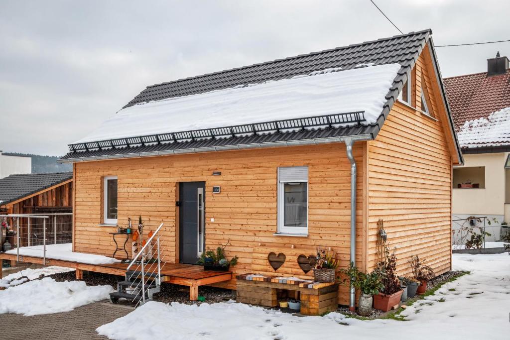 ein kleines Holzhaus mit Schnee auf dem Dach in der Unterkunft Ferienhaus Tiny Time in Krumbach