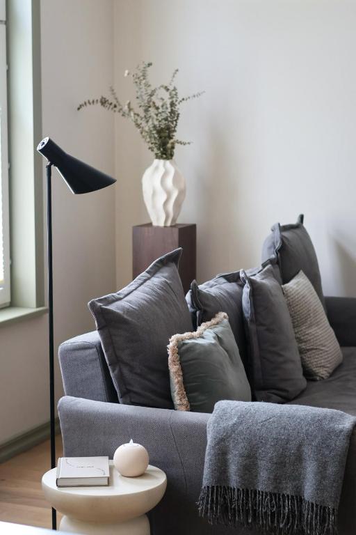 a living room with a blue couch with pillows at Vaksali Apartment, kaks minutit Ugalast in Viljandi