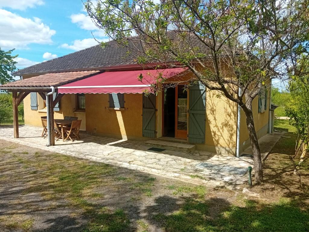 a small yellow house with a pink awning at La Bertrandie in Florimont-Gaumiers