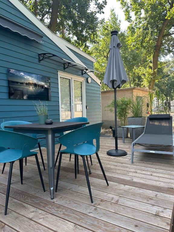 a patio with a table and chairs and an umbrella at Tiny House Nr 2 in Schwielowsee