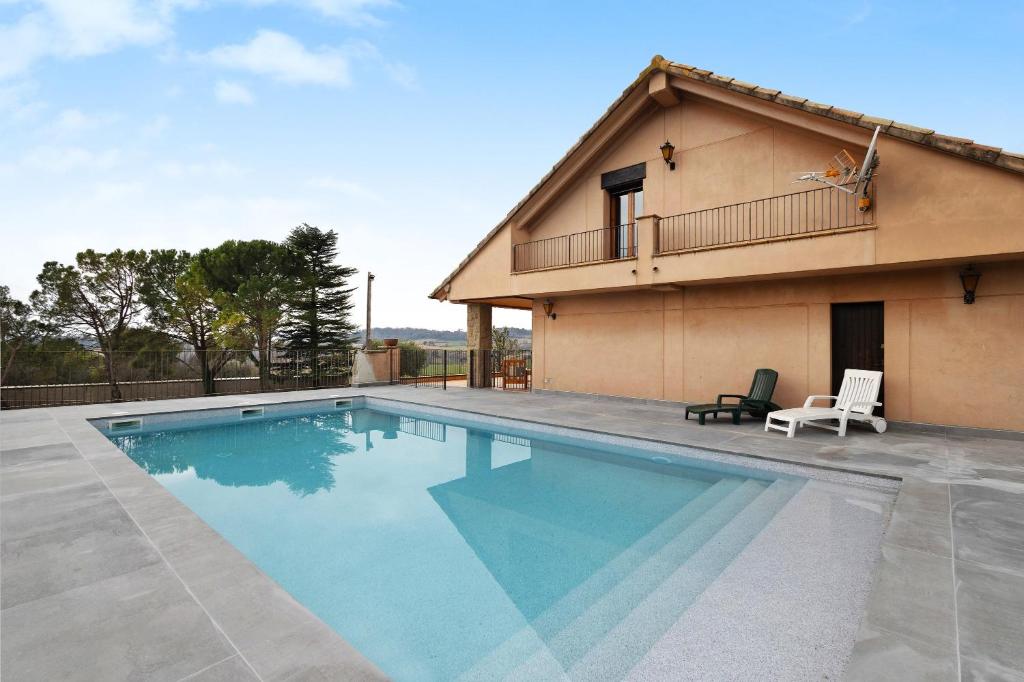 a swimming pool in front of a house at Casanova de Noet in Aviá