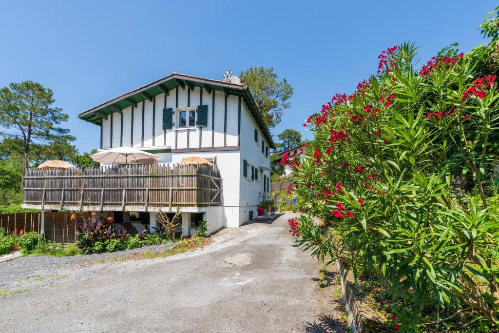 a white house with a balcony and some flowers at Vacances Pays Basque in Bidart