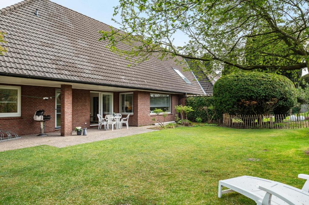a house with a yard with chairs and tables at Ferienhaus Auszeit Meer in Cuxhaven