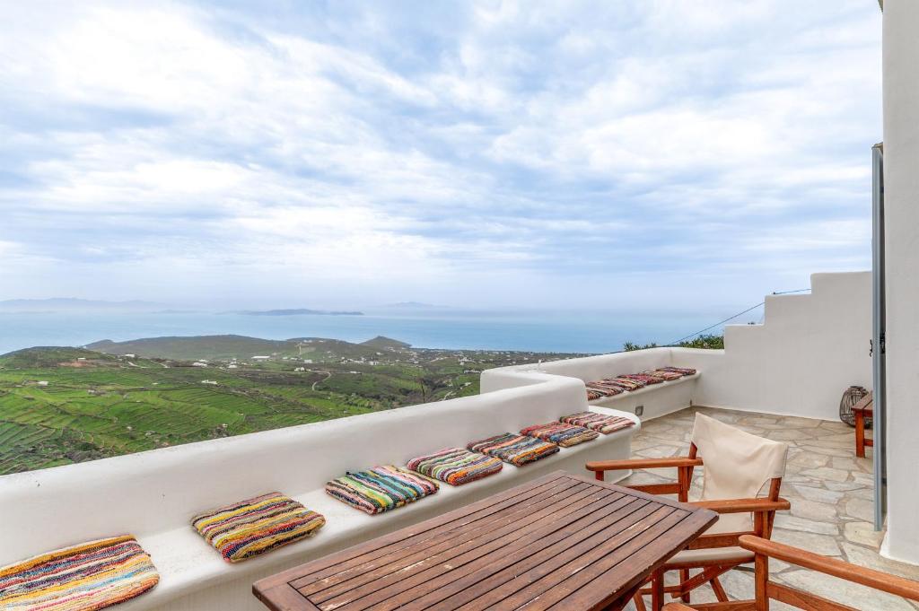 a balcony with a table and chairs and the ocean at Vassilis Family Villa Tinos in Triandáros