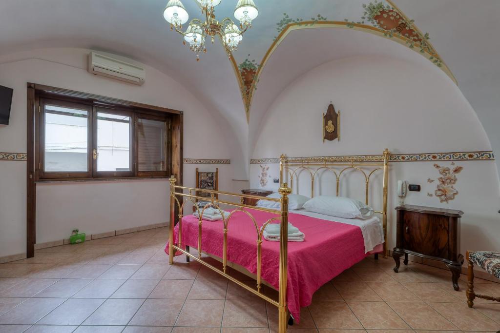 a bedroom with a bed with a pink blanket at Meraviglie Salentine - Lecce in Lequile