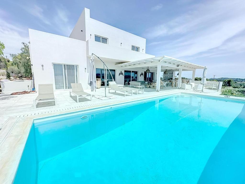 a swimming pool in front of a villa at The Privacy Villa by Seaviews in Porto Heli