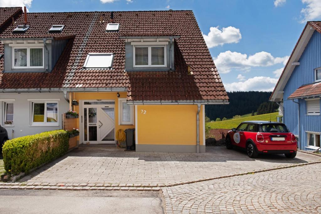 a red car parked in front of a house at Fewo Furtwangen in Furtwangen