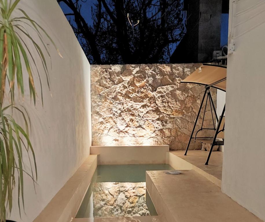 a stone wall with a bench and a table at Casa Colibri Central Villa with Private Pool and Tub Merida in Mérida
