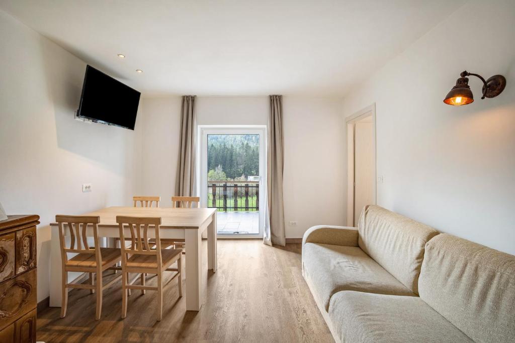a living room with a couch and a table at Silbernagl sonnig mit Gartenblick in Issengo