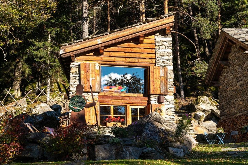 a small log cabin with a mirror in the window at Chalet Armonia Res Albert in San Guglielmo