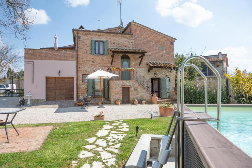 a villa with a swimming pool in front of a house at Tuscan Retreat Private Spa Villa in Lucignano