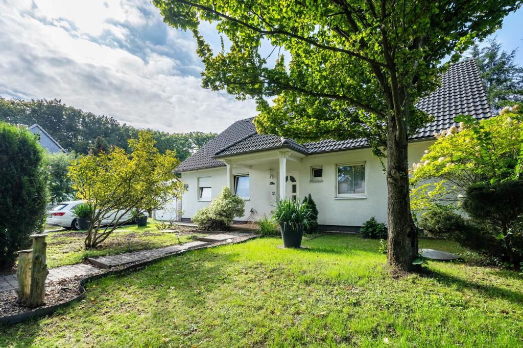 a white house with a tree in the yard at Ferienwohnung im Ländlichen Raum in Reuthen