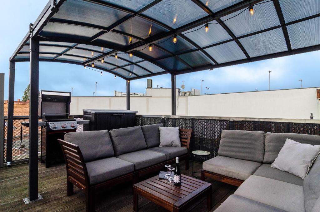 a patio with couches and a grill on a roof at Stadt-Loft mit Dachterrasse in Nordhausen