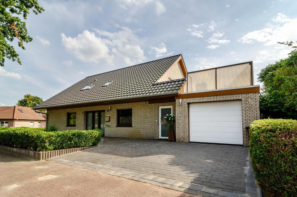 a brick house with a white garage at Ferienwohnung Bodenstein in Surwold