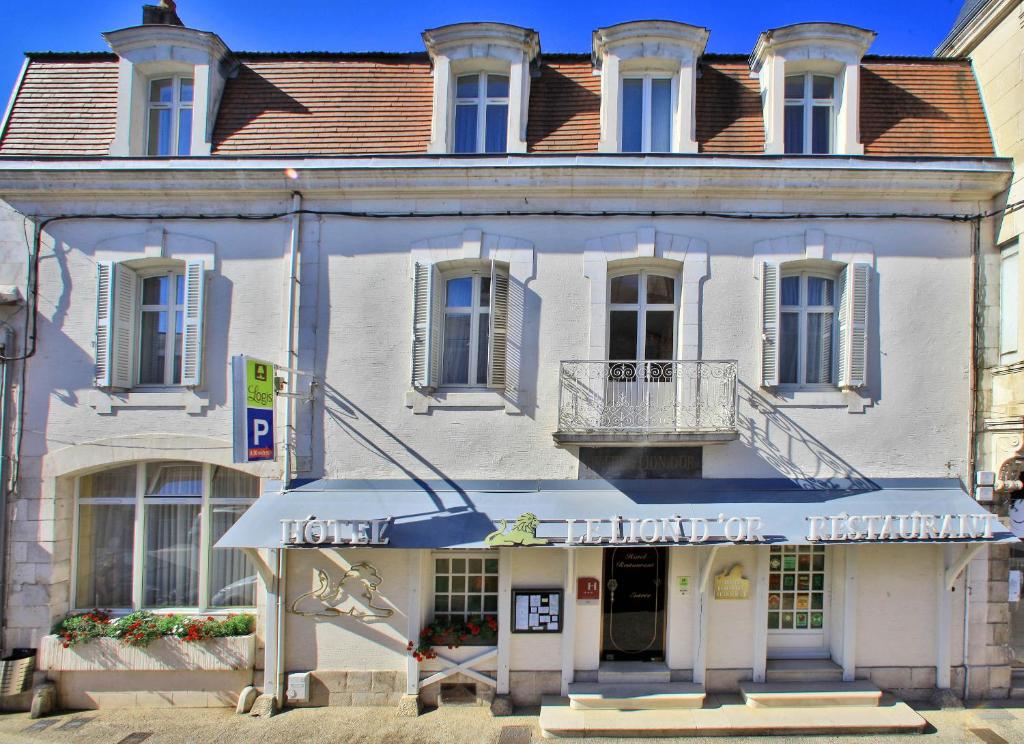 um edifício branco com um cartaz em Logis Hôtel Le Lion d'Or em Chauvigny