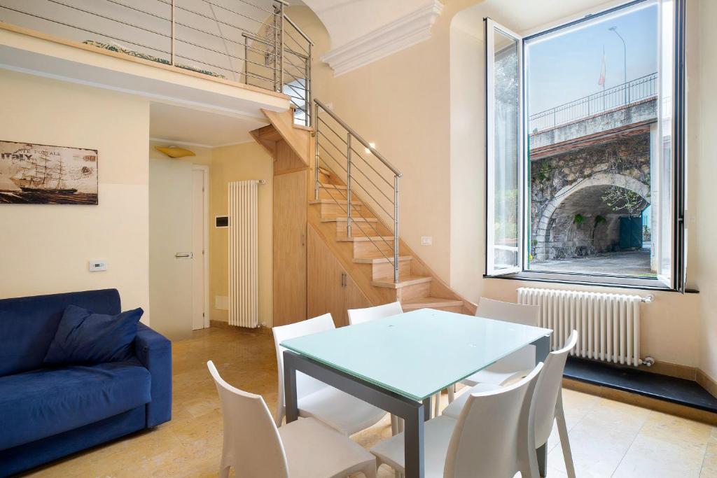 a living room with a blue table and white chairs at Conchiglia, borgo dei pescatori in Cervo