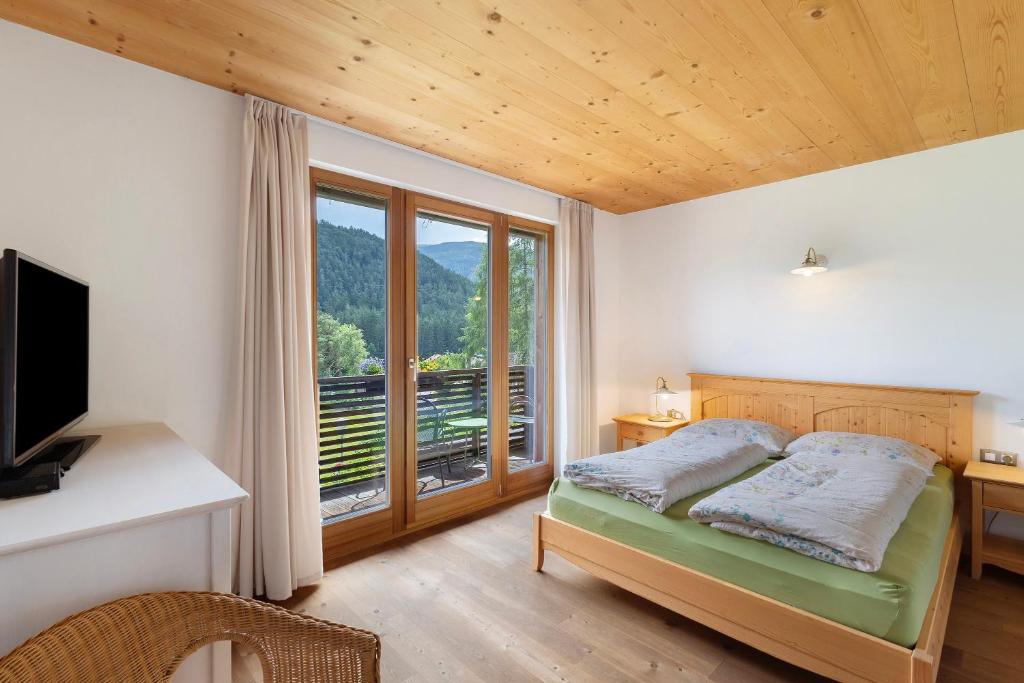 a bedroom with a bed and a large window at Silbernagl - Monolokal mit Ausblick in Issengo