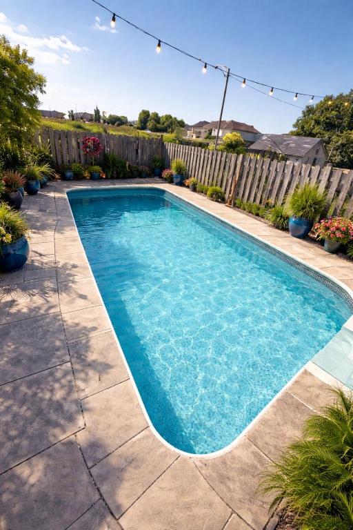 a swimming pool in a yard with a fence at Poolside Paradise minutes away from the Falls in Thorold