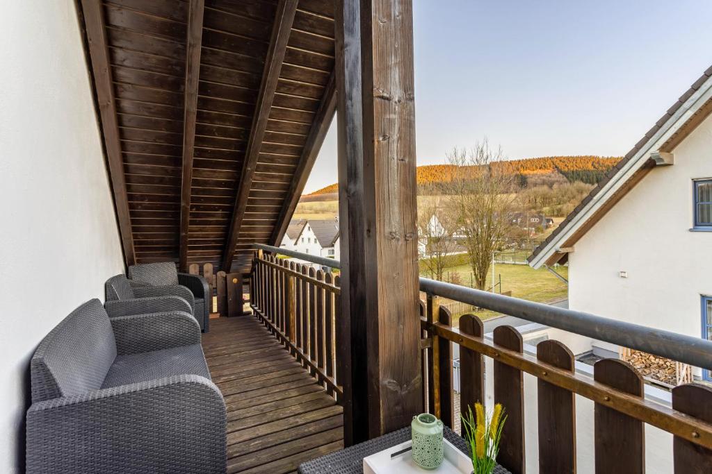 a balcony with chairs and a view of the countryside at Ferienwohnung Rinke in Schmallenberg