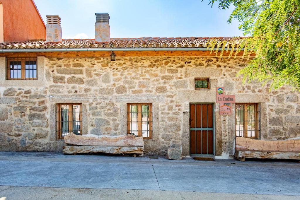 an old stone building with windows and doors at La Cantina in Villar de Corneja