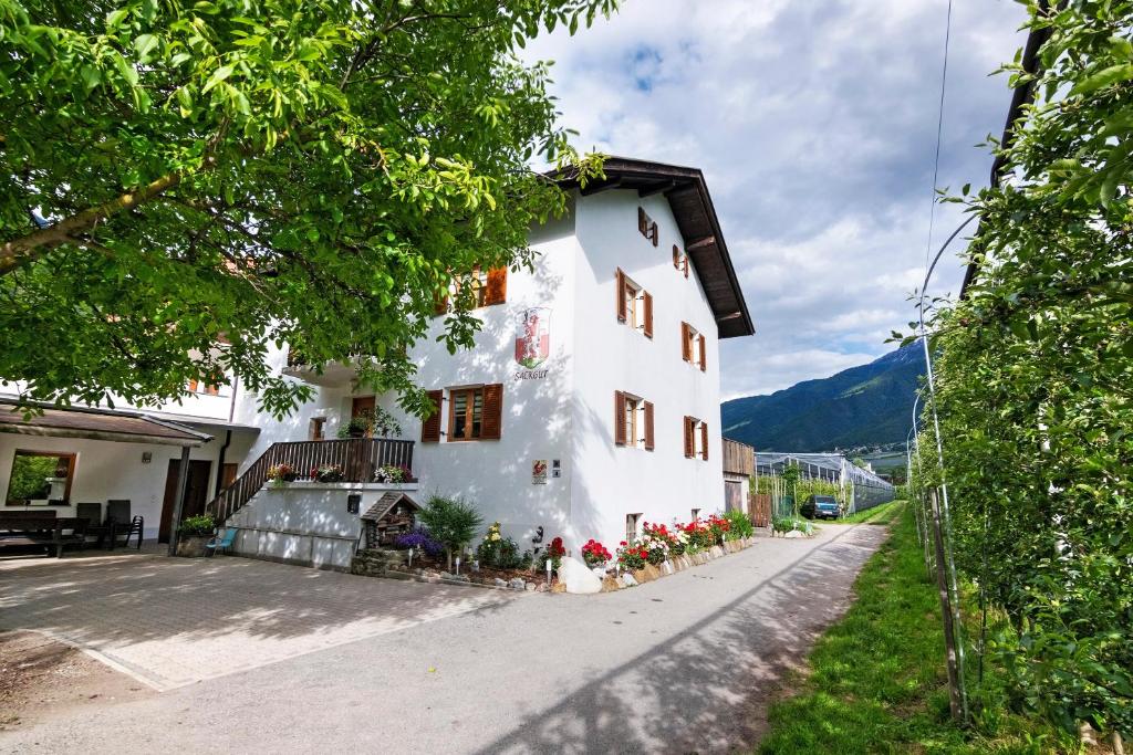 a white house with flowers on the side of it at Bauernhof Sackgut in Ciardes