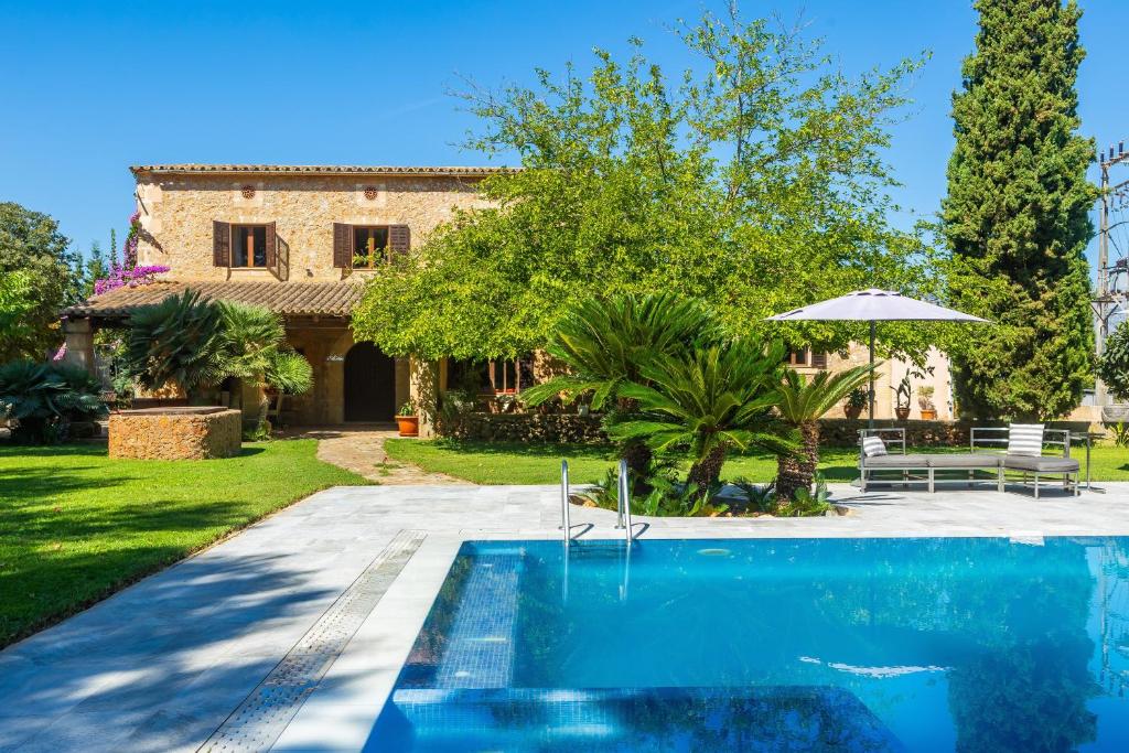 a swimming pool in front of a house at Es Pouet in Binissalem
