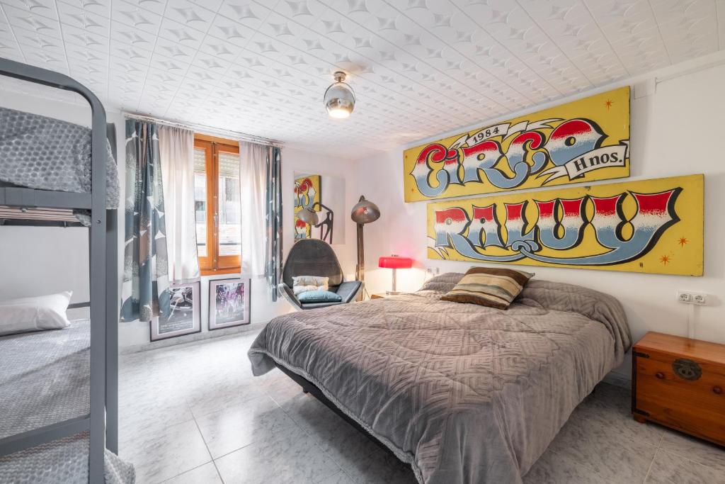 a bedroom with a bed and a large painting on the wall at La Fabriqueta Studio in Ríudecañas