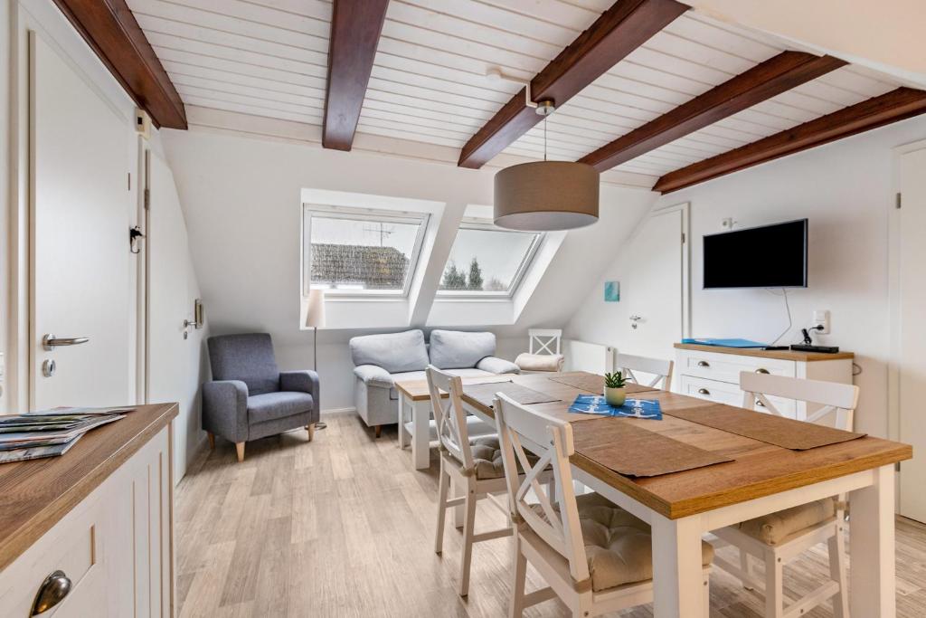 a kitchen and dining room with a table and chairs at Ferienwohnung Backbord Deichhausen in Büsumer Deichhausen