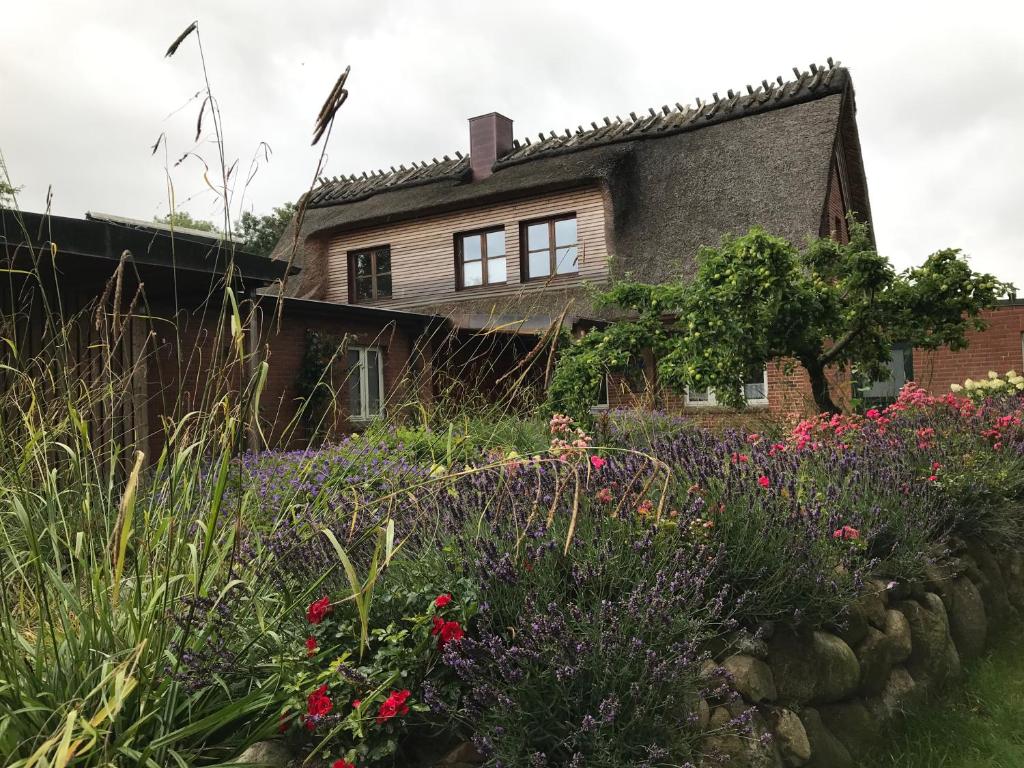 ein Haus mit einem Garten mit Blumen davor in der Unterkunft Olendeel in Gelting