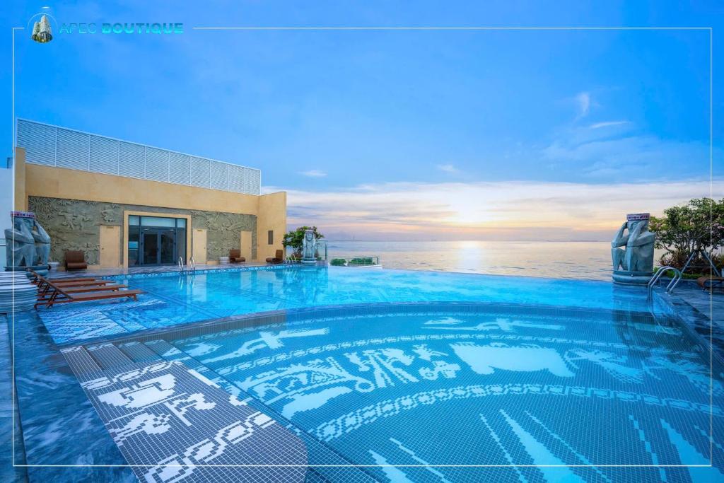 a large swimming pool with the ocean in the background at Apec Beach Luxury Phú Yên in Tuy Hoa