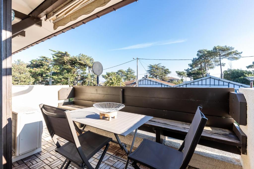 a patio with a table and chairs on a balcony at Escapade au Cap Ferret -Réf 24 in Lège-Cap-Ferret
