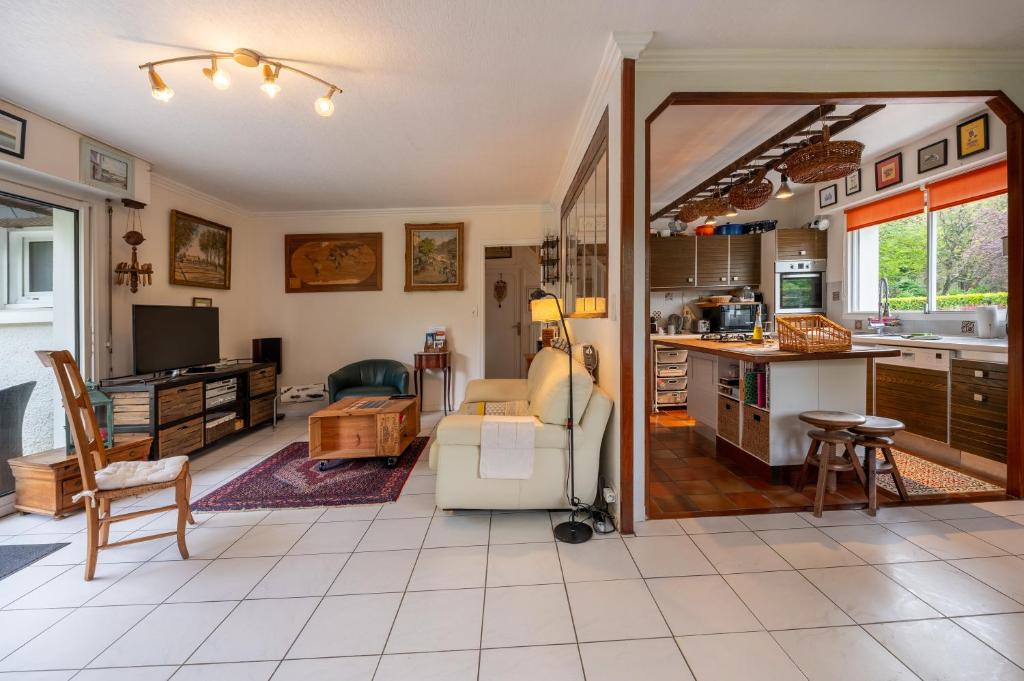a living room with a couch and a kitchen at Ty Clafout wifi parking in Saint-Nolff