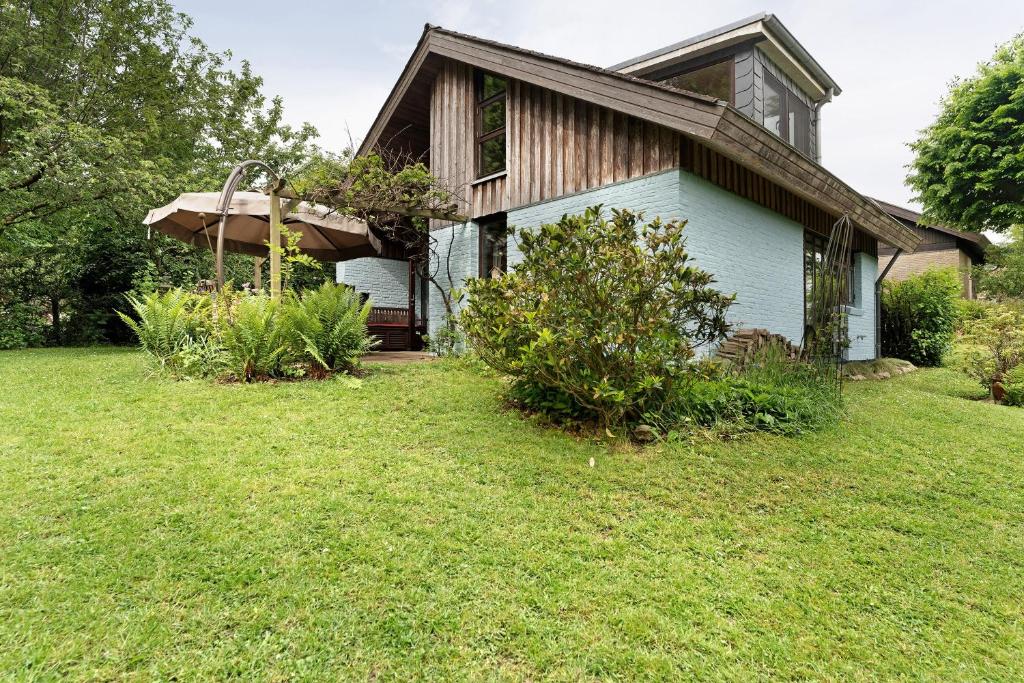 a house with a grass yard in front of it at Ferienhaus Karlsminde in Waabs