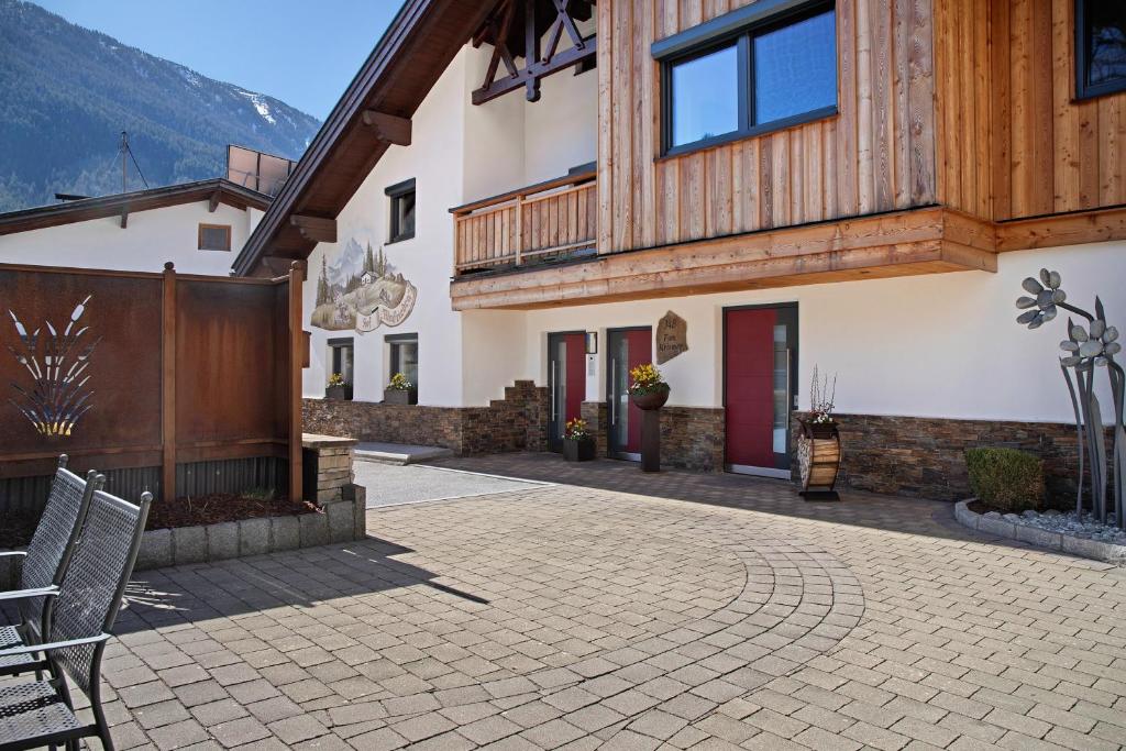 a building with a patio with chairs in front of it at Hof Almfrieden - Dormitz in Nassereith