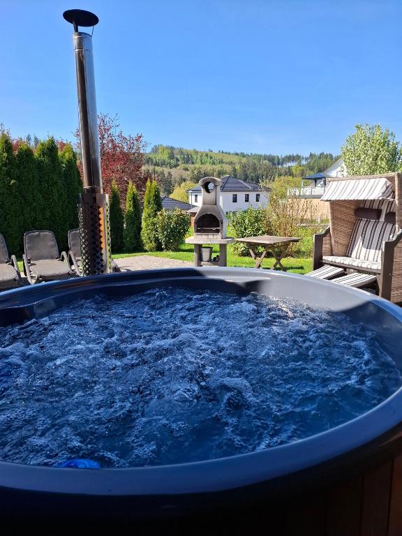 a jacuzzi tub in the backyard with a view at Holzhaus Zum Radekopf mit Whirlpool in Medebach