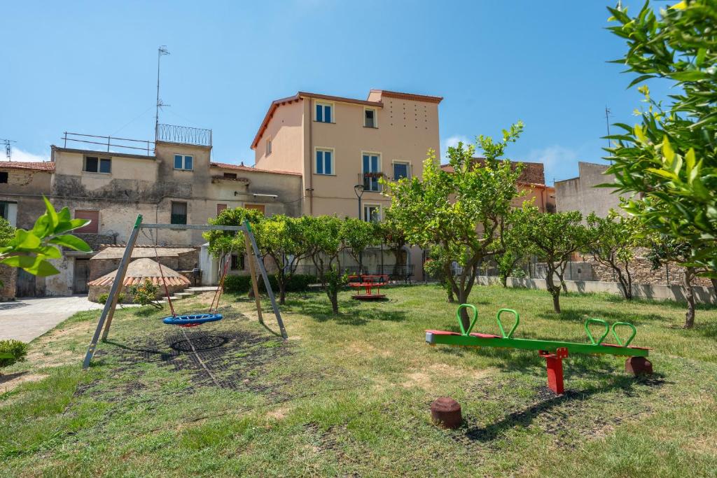 a park with swings and trees and a building at Dimora Borgo Antico Lucia in Ascea
