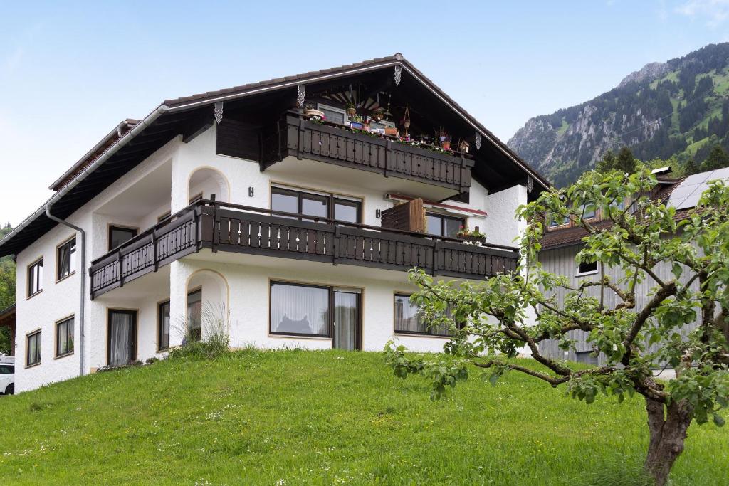 a building with people sitting on a balcony at Ferienwohnung Wendelinus in Rettenberg