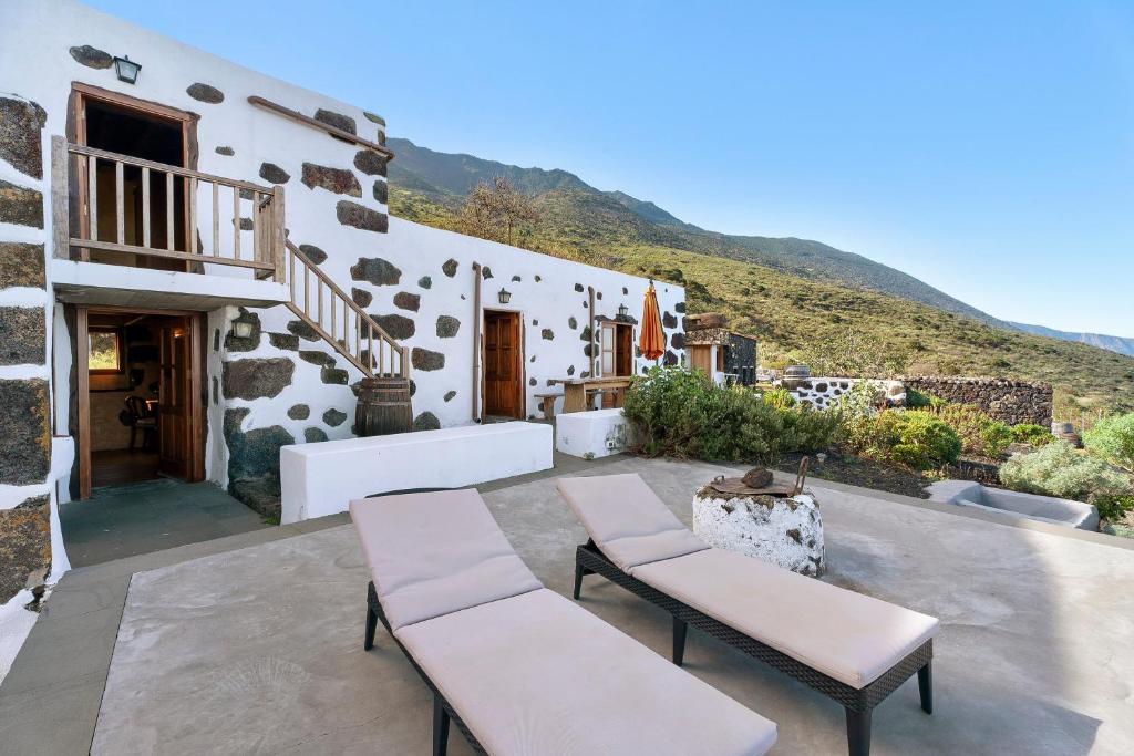 a patio with two benches and a building at El Lagar in Frontera