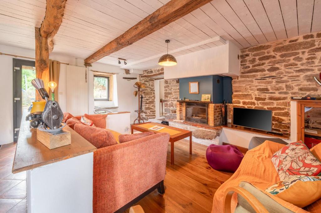 a living room with a stone wall at Ville Moizo in Sérent
