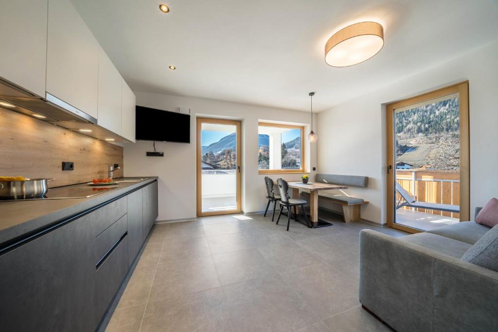 a kitchen and living room with a couch and a table at sunnig Apartment Sonnenlicht in Vollan