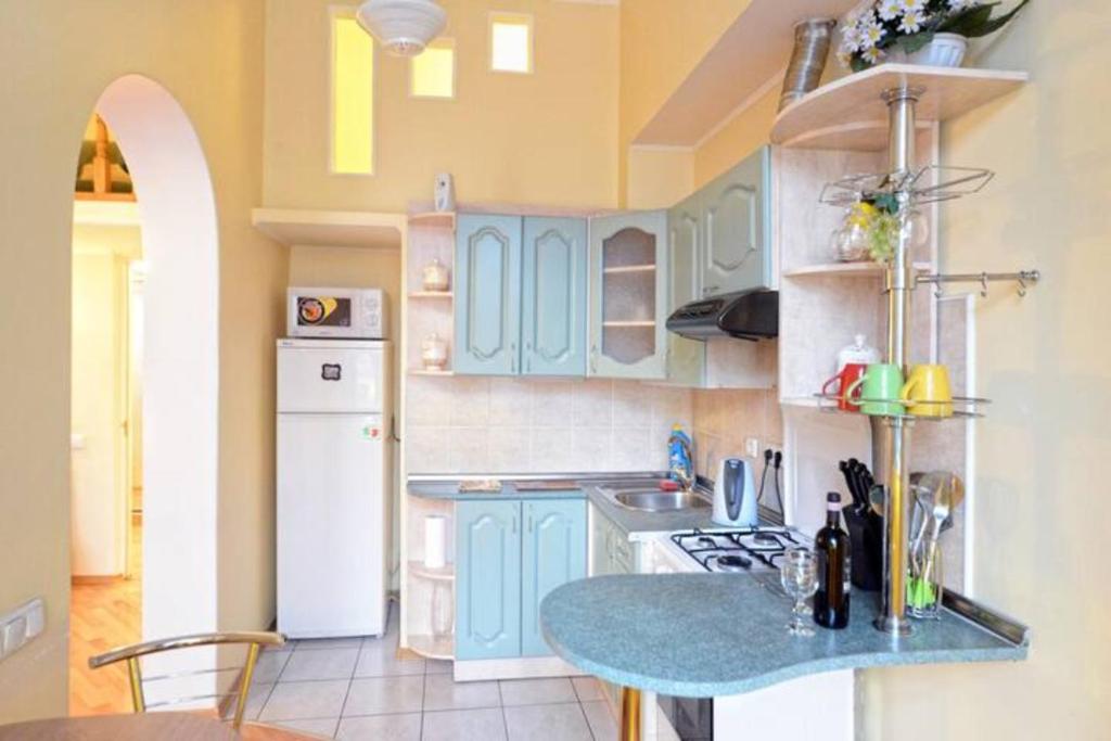 a kitchen with blue cabinets and a table in it at Михайловская in Kyiv